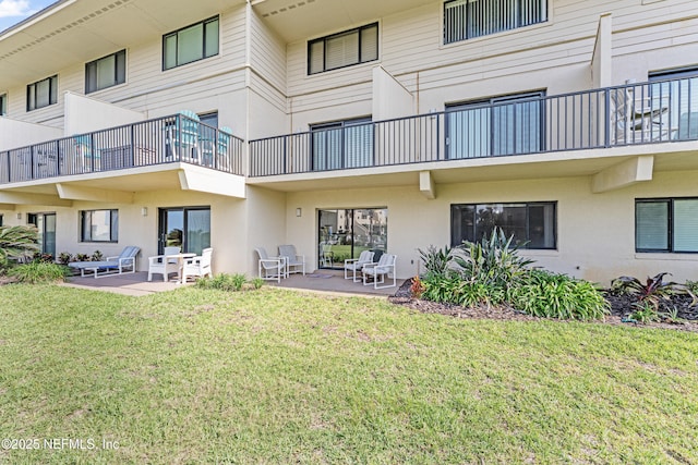 8550 A1A S Unit 14151, Saint Augustine, FL 32080 - rear view of house featuring stucco siding, a patio area, a balcony, and a yard