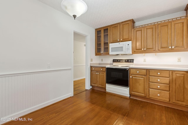 2520 Elbow Rd, Orange Park, FL 32073 - kitchen featuring white appliances, dark wood-style flooring, light countertops, glass insert cabinets, and brown cabinetry