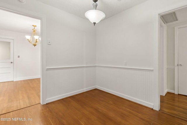 2520 Elbow Rd, Orange Park, FL 32073 - spare room featuring wood finished floors, a chandelier, baseboards, and wainscoting