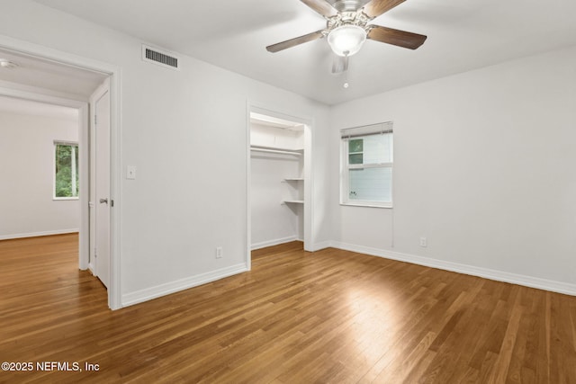 2520 Elbow Rd, Orange Park, FL 32073 - unfurnished bedroom featuring wood finished floors, multiple windows, baseboards, and a closet