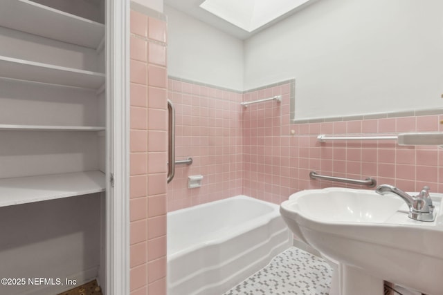 2520 Elbow Rd, Orange Park, FL 32073 - bathroom featuring a sink, washtub / shower combination, a skylight, and tile walls