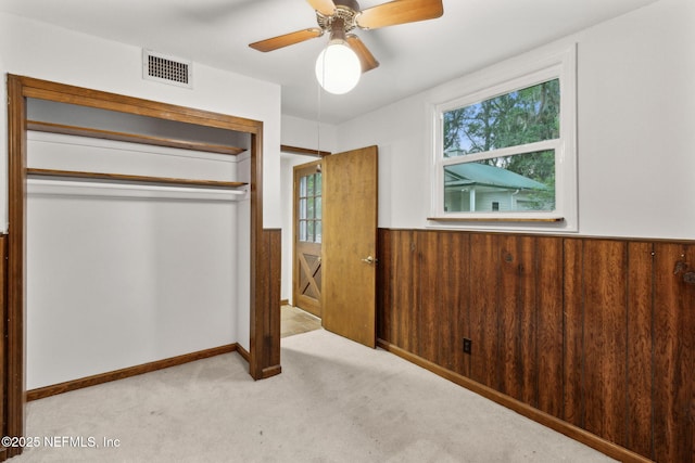 2520 Elbow Rd, Orange Park, FL 32073 - unfurnished bedroom with a wainscoted wall, a closet, multiple windows, carpet flooring, and ceiling fan