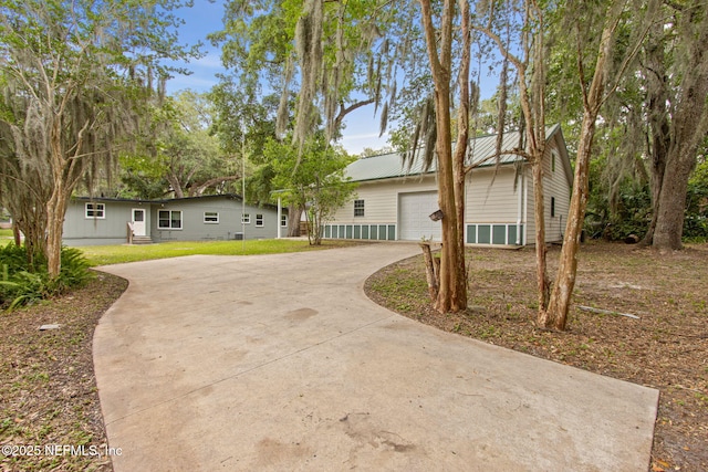 2520 Elbow Rd, Orange Park, FL 32073 - ranch-style house featuring driveway, an attached garage, metal roof, and a front lawn