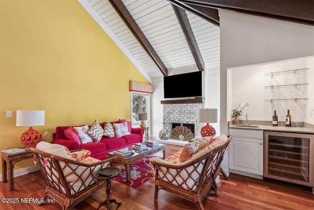 3429 Sea Marsh Rd, Fernandina Beach, FL 32034 - living area featuring wine cooler, bar with sink, beamed ceiling, wood finished floors, and a fireplace