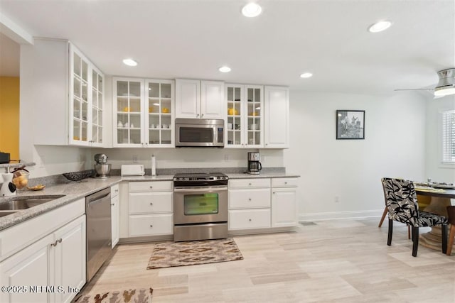 3429 Sea Marsh Rd, Fernandina Beach, FL 32034 - kitchen with stainless steel appliances, recessed lighting, white cabinetry, light stone countertops, and light wood-type flooring