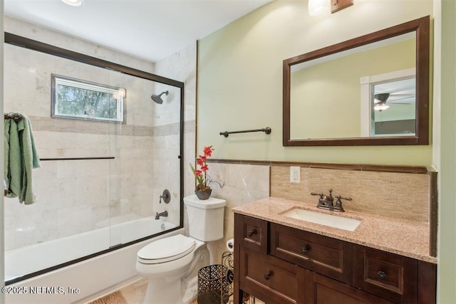 3429 Sea Marsh Rd, Fernandina Beach, FL 32034 - bathroom featuring tile walls, toilet, vanity, combined bath / shower with glass door, and wainscoting