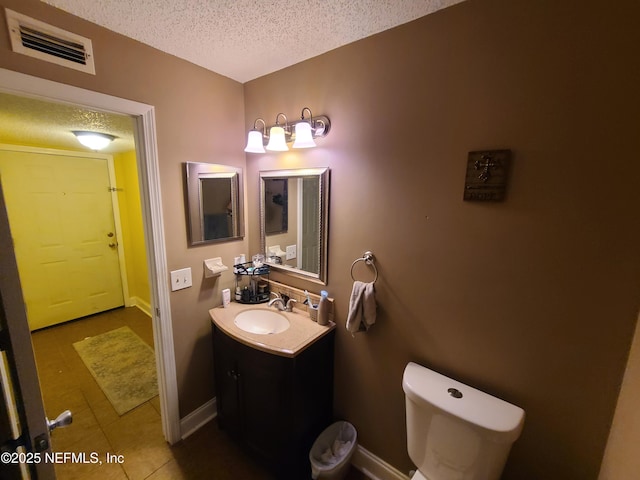 8741 Whispering Pines Dr, Jacksonville, FL 32244 - bathroom with a textured ceiling, vanity, tile patterned flooring, toilet, and baseboards