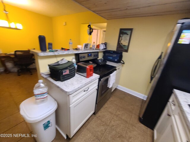 8741 Whispering Pines Dr, Jacksonville, FL 32244 - kitchen featuring stainless steel electric range, a peninsula, light countertops, white cabinetry, and tile patterned flooring