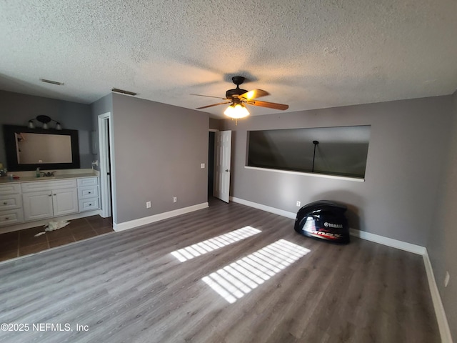 8741 Whispering Pines Dr, Jacksonville, FL 32244 - unfurnished living room with dark wood finished floors, a textured ceiling, baseboards, ceiling fan, and a sink