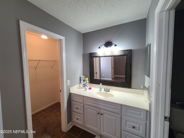 8741 Whispering Pines Dr, Jacksonville, FL 32244 - bathroom featuring vanity, a textured ceiling, and a spacious closet