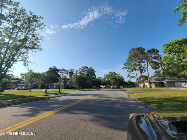 8741 Whispering Pines Dr, Jacksonville, FL 32244 - view of asphalt street with curbs, a residential view, and sidewalks