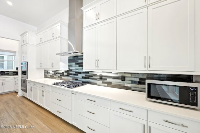 210 Terra Oaks Dr, Saint Johns, FL 32259 - kitchen featuring stainless steel appliances, wall chimney exhaust hood, tasteful backsplash, and white cabinetry