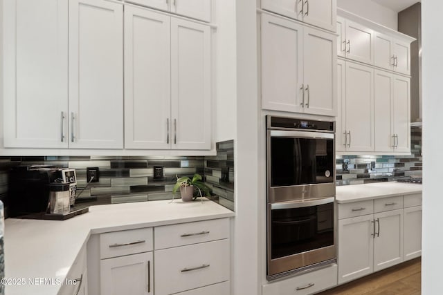 210 Terra Oaks Dr, Saint Johns, FL 32259 - kitchen with double oven, decorative backsplash, light countertops, white cabinetry, and wood finished floors