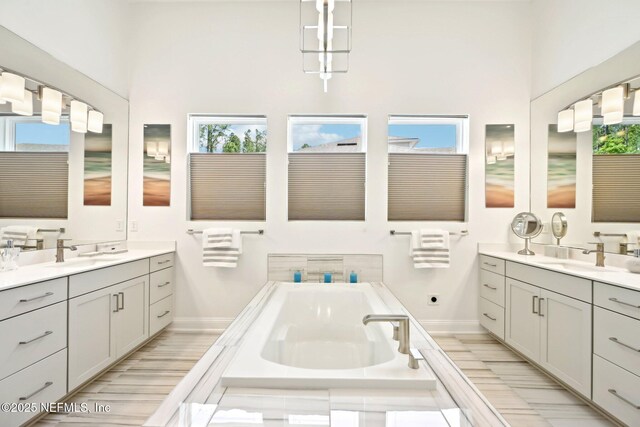 210 Terra Oaks Dr, Saint Johns, FL 32259 - full bath with two vanities, a high ceiling, a garden tub, and baseboards