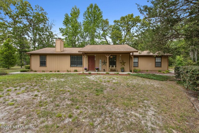 single story home with covered porch and a chimney