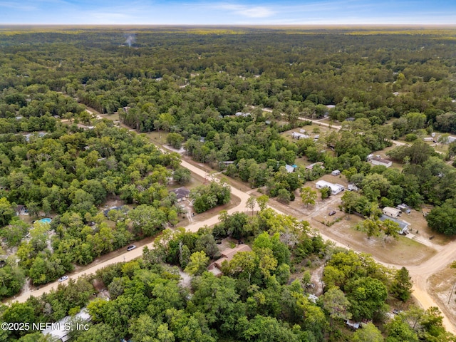 aerial view of property and surrounding area with a heavily wooded area