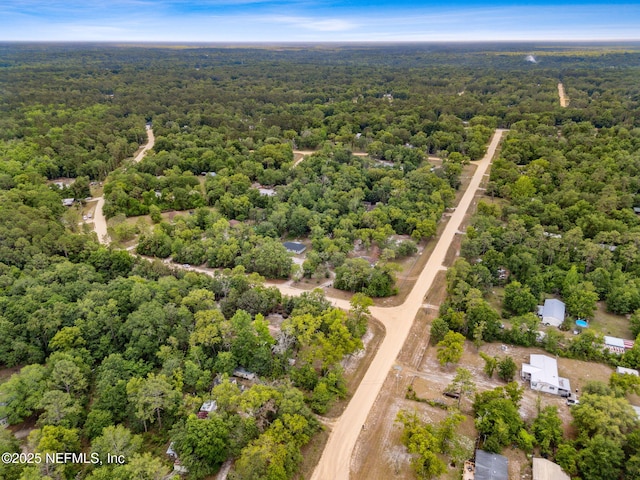 aerial view of property and surrounding area with a heavily wooded area