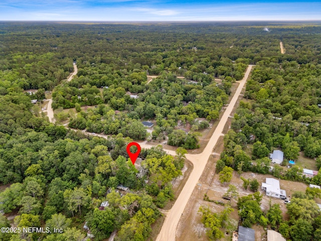 aerial view of property and surrounding area featuring a forest