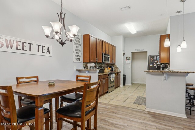 607 Golden Lake Loop, Saint Augustine, FL 32084 - kitchen with stainless steel appliances, tasteful backsplash, light stone countertops, and a kitchen bar