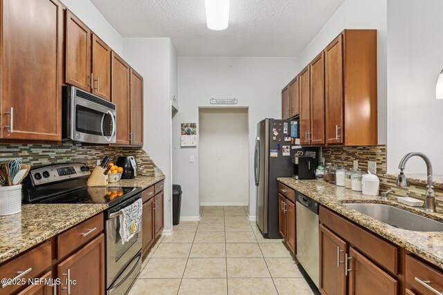 607 Golden Lake Loop, Saint Augustine, FL 32084 - kitchen featuring appliances with stainless steel finishes, a sink, tasteful backsplash, light stone counters, and a textured ceiling