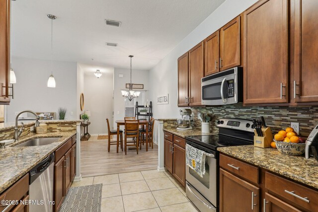 607 Golden Lake Loop, Saint Augustine, FL 32084 - kitchen with stainless steel appliances, a sink, backsplash, and light stone countertops