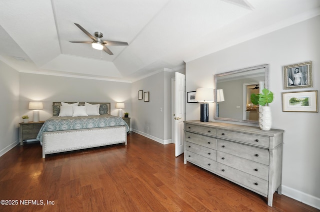 bedroom with a tray ceiling, dark wood-type flooring, baseboards, ornamental molding, and a ceiling fan