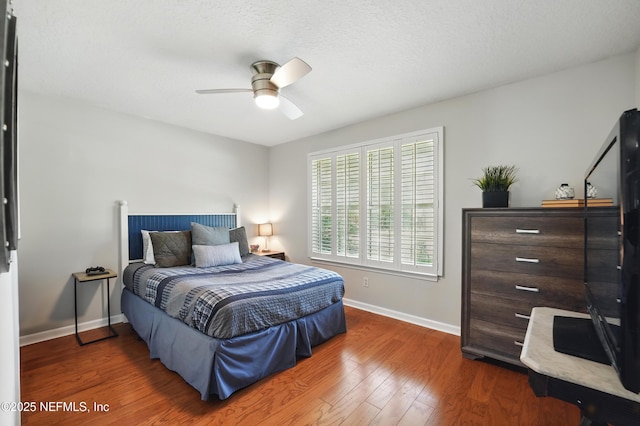 bedroom with baseboards, wood finished floors, and a ceiling fan