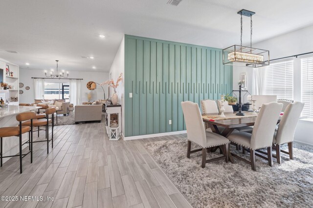 dining space with a chandelier, wood finished floors, recessed lighting, and baseboards