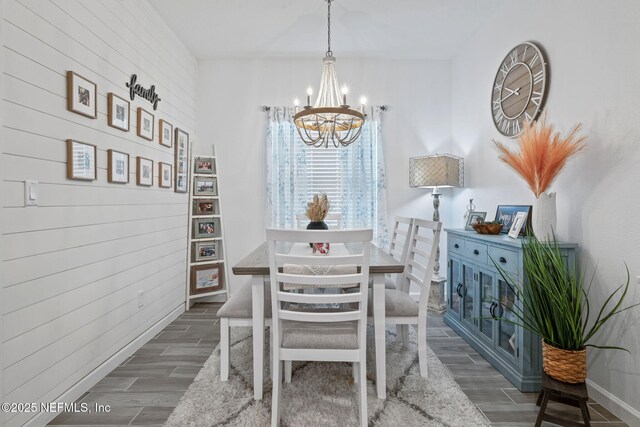 dining area with a chandelier, wood finish floors, and baseboards
