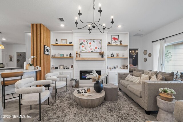 living area featuring a chandelier and a large fireplace