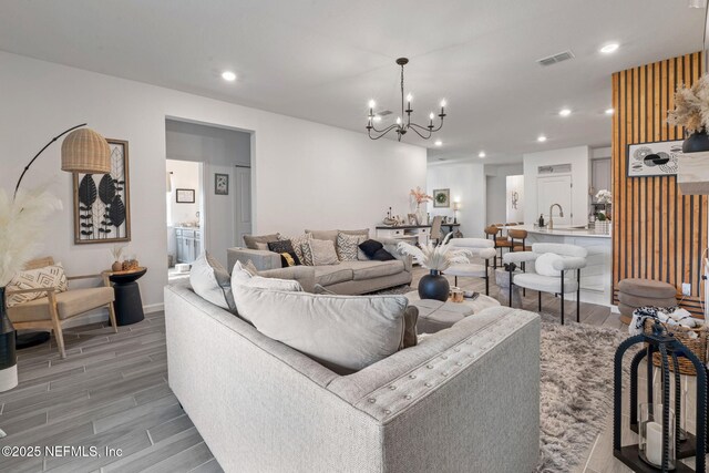 living area with a chandelier, light wood finished floors, recessed lighting, and baseboards