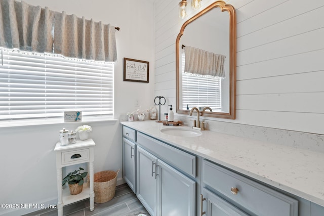 bathroom with plenty of natural light, vanity, and wood walls