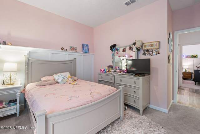 bedroom featuring light carpet and baseboards