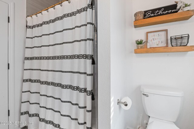 full bathroom with toilet and curtained shower