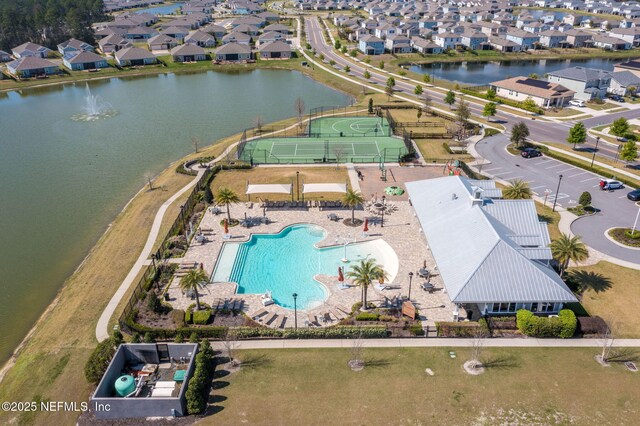 aerial view of residential area featuring a pool and a large body of water