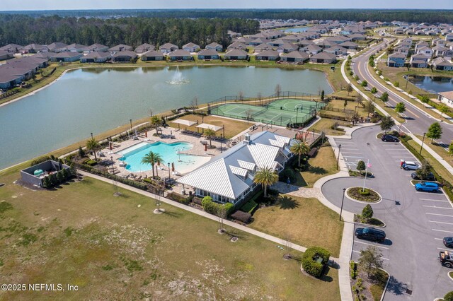 aerial view of residential area featuring a pool and a nearby body of water