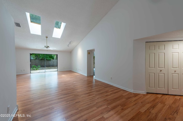 4837 Wethersfield Pl W, Jacksonville, FL 32257 - unfurnished living room featuring a skylight, light wood-style flooring, high vaulted ceiling, and baseboards