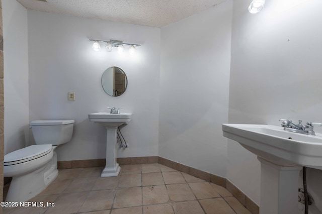 4837 Wethersfield Pl W, Jacksonville, FL 32257 - half bathroom featuring toilet, a textured ceiling, tile patterned floors, baseboards, and a sink