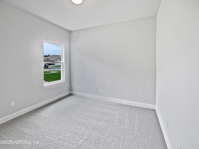 carpeted empty room with baseboards