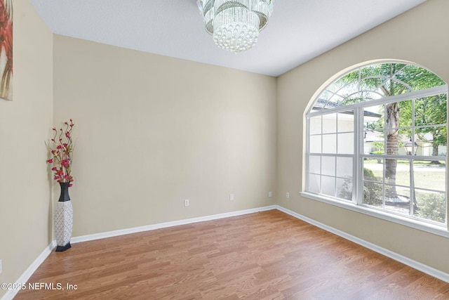 11658 Jerry Adam Ct, Jacksonville, FL 32218 - spare room with a chandelier, light wood-style floors, and baseboards