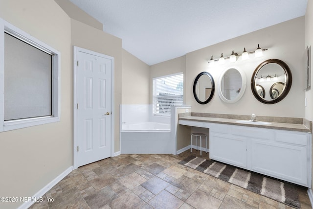 11658 Jerry Adam Ct, Jacksonville, FL 32218 - full bathroom with a garden tub, baseboards, stone finish floors, lofted ceiling, and vanity