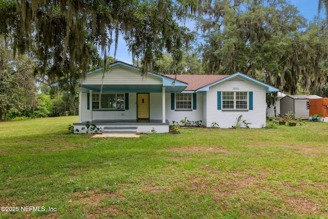 1874 Clinch Dr, Fernandina Beach, FL 32034 - ranch-style home with a porch, a front lawn, a shed, and an outdoor structure