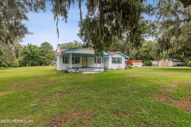 1874 Clinch Dr, Fernandina Beach, FL 32034 - view of front of house featuring a porch, a front lawn, and a chimney