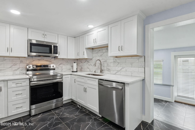1874 Clinch Dr, Fernandina Beach, FL 32034 - kitchen featuring appliances with stainless steel finishes, a sink, dark marble finish floors, white cabinetry, and recessed lighting