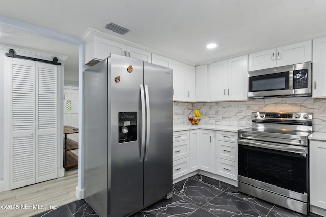 1874 Clinch Dr, Fernandina Beach, FL 32034 - kitchen featuring appliances with stainless steel finishes, light countertops, white cabinetry, decorative backsplash, and recessed lighting