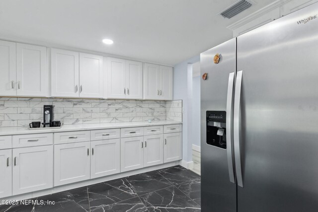 1874 Clinch Dr, Fernandina Beach, FL 32034 - kitchen with stainless steel fridge, dark marble finish floors, white cabinetry, light countertops, and recessed lighting