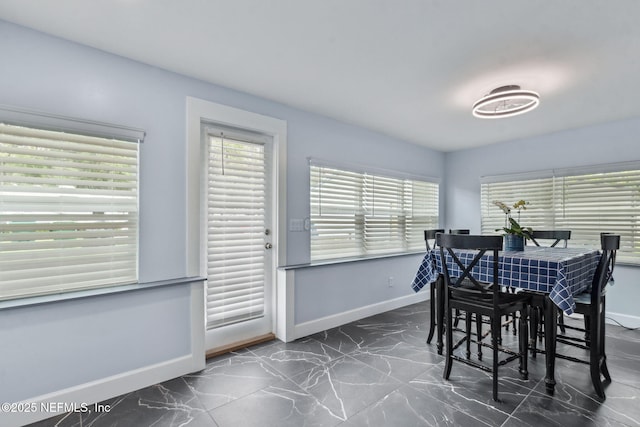 1874 Clinch Dr, Fernandina Beach, FL 32034 - dining room featuring baseboards, dark marble finish floors, and plenty of natural light