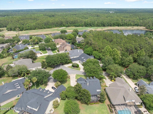 aerial view of residential area with a forest and a nearby body of water