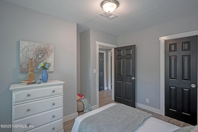 304 Lawton Ave, Jacksonville, FL 32208 - bedroom featuring wood finished floors, baseboards, and a textured ceiling
