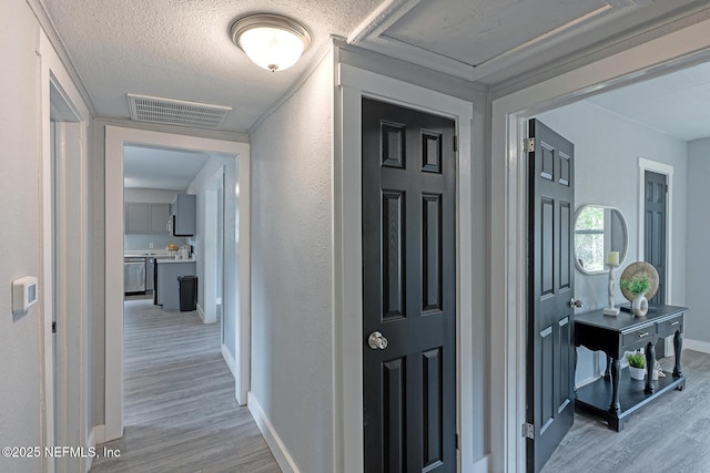 304 Lawton Ave, Jacksonville, FL 32208 - hall featuring light wood-style floors, baseboards, and a textured wall